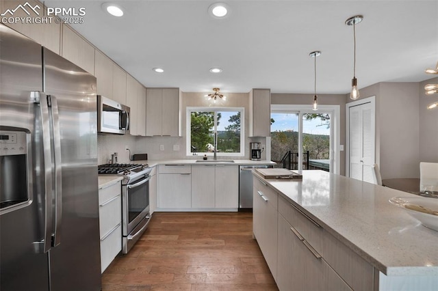 kitchen featuring dark wood-style flooring, recessed lighting, tasteful backsplash, a sink, and appliances with stainless steel finishes