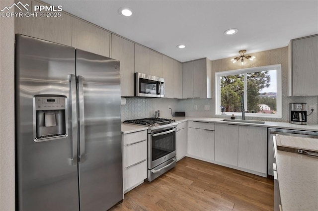 kitchen with light countertops, a sink, decorative backsplash, and stainless steel appliances