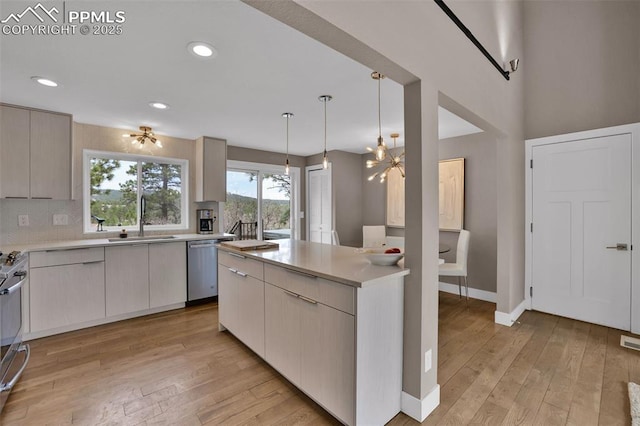 kitchen featuring a sink, light countertops, light wood-style floors, and stainless steel appliances