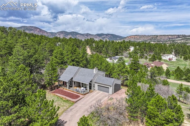 birds eye view of property featuring a view of trees and a mountain view