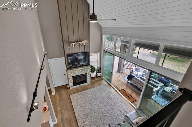 living room featuring a ceiling fan, high vaulted ceiling, wood finished floors, and a fireplace