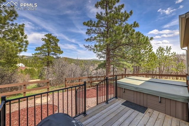 wooden terrace featuring a hot tub and fence