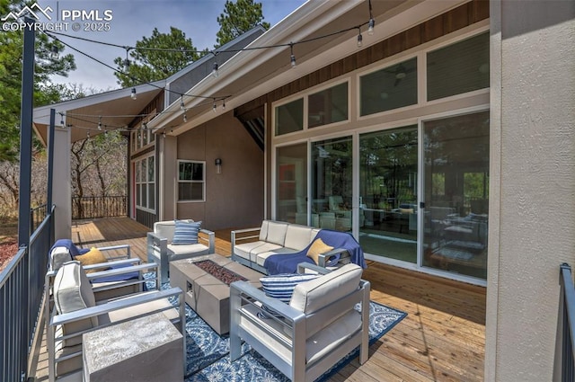 wooden deck with an outdoor living space with a fire pit
