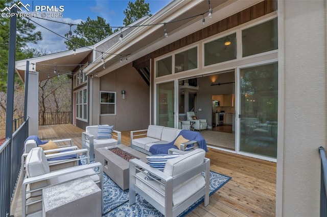 deck with an outdoor living space with a fire pit
