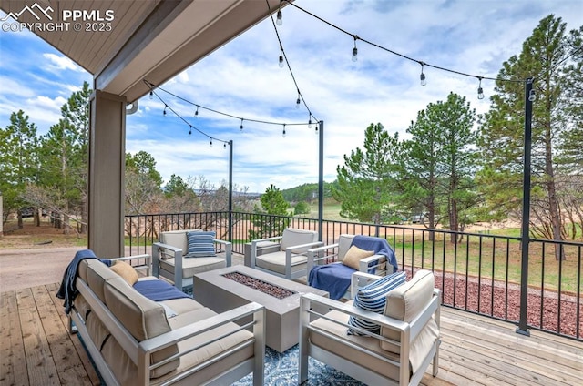 wooden deck with an outdoor living space with a fire pit
