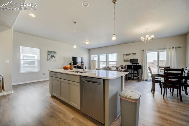 kitchen with stainless steel dishwasher, plenty of natural light, a sink, and light countertops
