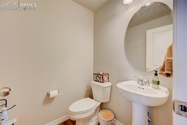 bathroom with baseboards and toilet