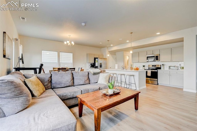living room featuring visible vents, recessed lighting, light wood-style flooring, and a chandelier