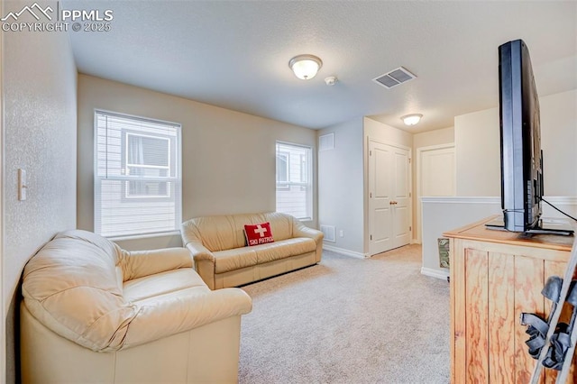 carpeted living area featuring baseboards and visible vents