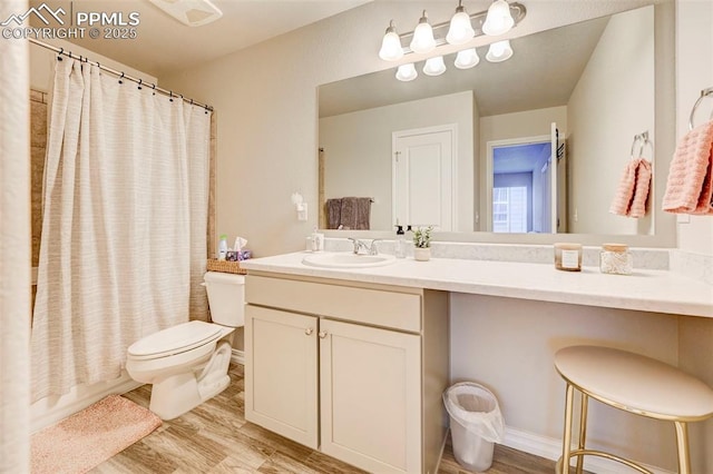 bathroom with toilet, wood finished floors, and vanity