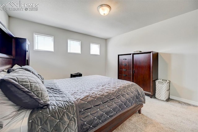 bedroom with baseboards and light carpet