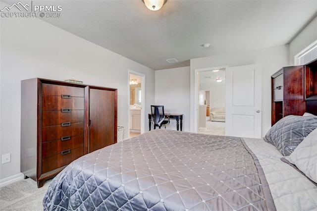 bedroom featuring carpet floors, baseboards, visible vents, and ensuite bath
