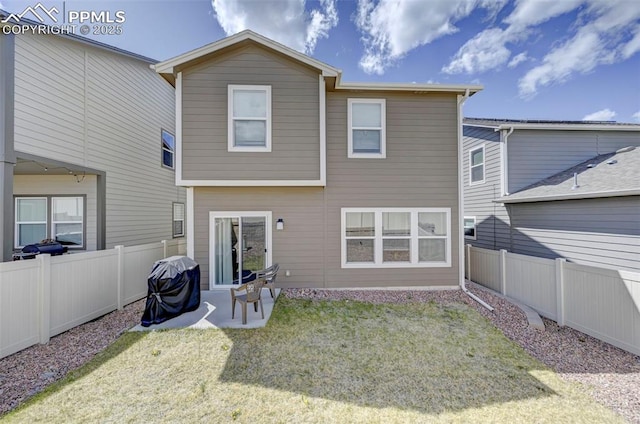 rear view of house with a fenced backyard, a patio, and a yard