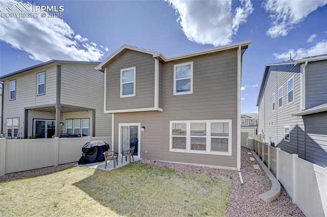 back of house with a fenced backyard, a patio, and a yard
