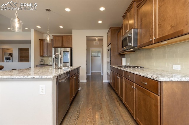 1849 Mud Hen Dr, Colorado Springs, CO 80921 - kitchen with stainless steel appliances, a sink, decorative backsplash, dark wood finished floors, and recessed lighting
