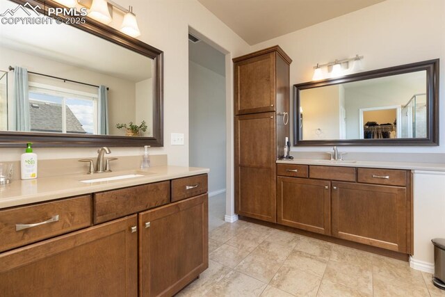 1849 Mud Hen Dr, Colorado Springs, CO 80921 - bathroom featuring two vanities, baseboards, and tile patterned flooring