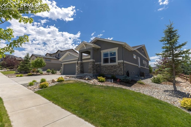1849 Mud Hen Dr, Colorado Springs, CO 80921 - craftsman house with stone siding, stucco siding, driveway, a front yard, and an attached garage