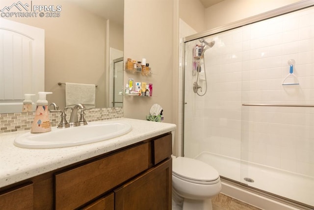 1849 Mud Hen Dr, Colorado Springs, CO 80921 - bathroom featuring a shower stall, toilet, vanity, and tasteful backsplash