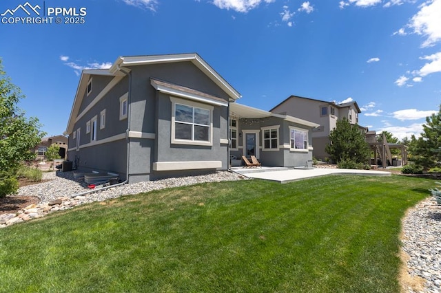 1849 Mud Hen Dr, Colorado Springs, CO 80921 - back of house featuring stucco siding, a patio, and a lawn