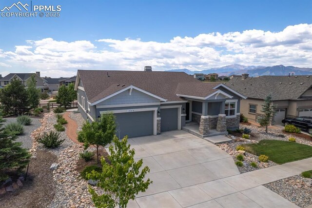 1849 Mud Hen Dr, Colorado Springs, CO 80921 - craftsman inspired home featuring an attached garage, concrete driveway, stone siding, a mountain view, and a shingled roof