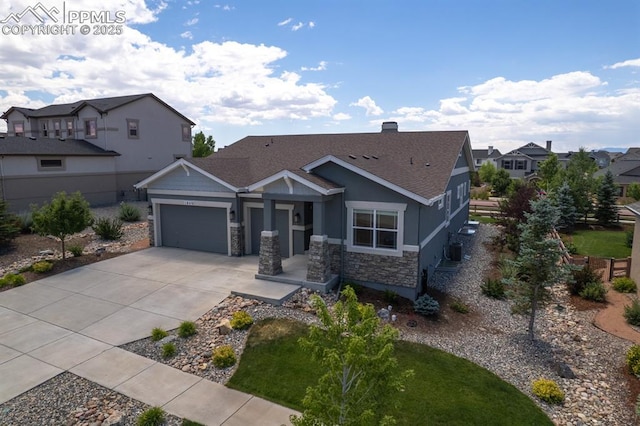 1849 Mud Hen Dr, Colorado Springs, CO 80921 - view of front of property with an attached garage, driveway, stone siding, roof with shingles, and a residential view
