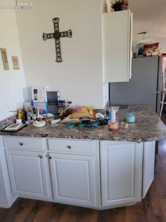 823 7th St, Hugo, CO 80821 - kitchen with white cabinets, dark wood-style floors, and freestanding refrigerator