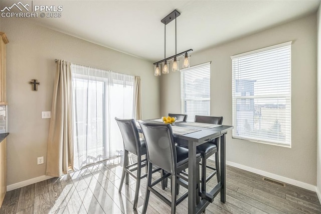 dining room with baseboards and light wood-type flooring