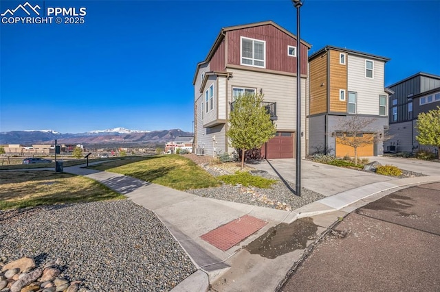 view of front of house with a mountain view, concrete driveway, and an attached garage
