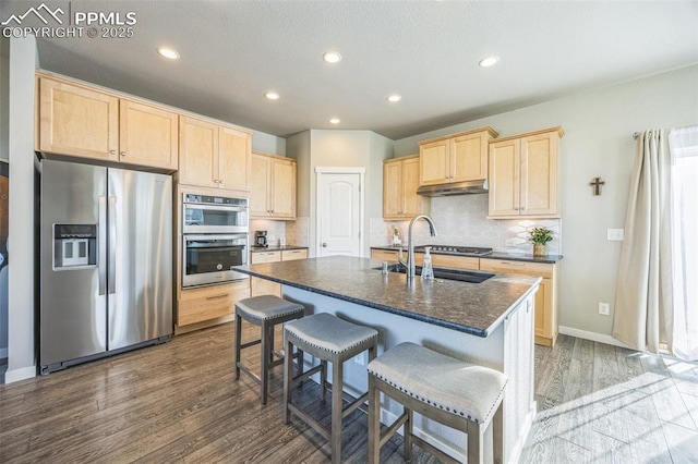 kitchen with stainless steel appliances, light brown cabinets, a sink, under cabinet range hood, and recessed lighting