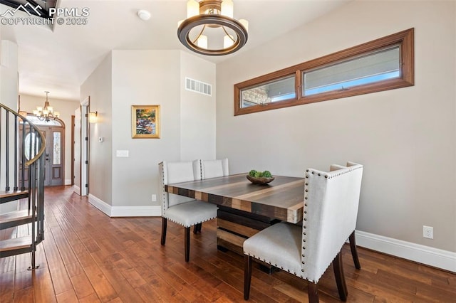 dining area featuring visible vents, baseboards, a chandelier, and hardwood / wood-style flooring