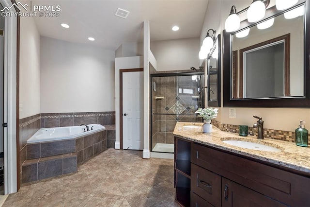 bathroom with a garden tub, visible vents, a shower stall, vanity, and recessed lighting