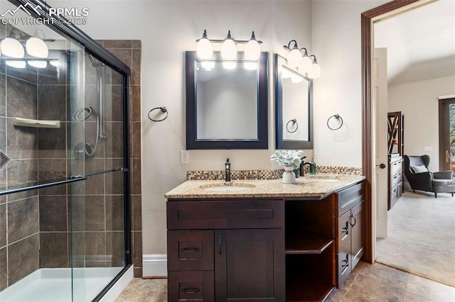 full bathroom with double vanity, a sink, and a stall shower