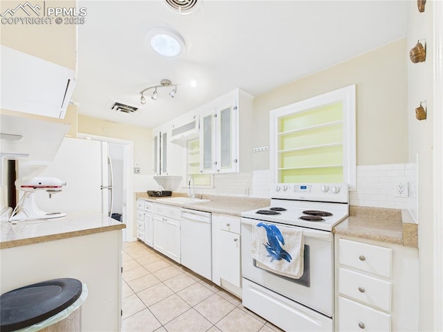 kitchen featuring visible vents, light tile patterned flooring, white appliances, and tasteful backsplash