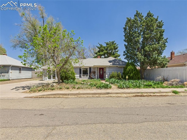 single story home featuring concrete driveway and fence