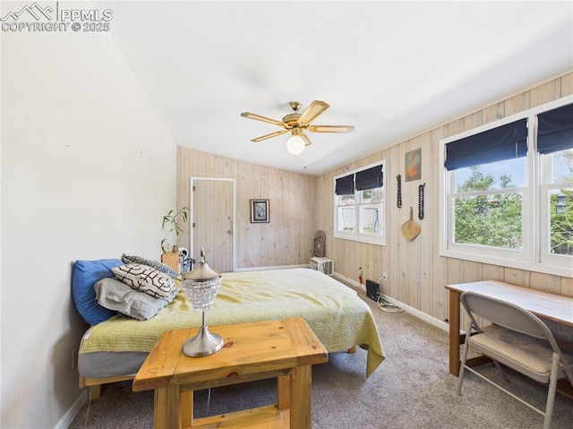 bedroom featuring baseboards, a ceiling fan, carpet, and wooden walls