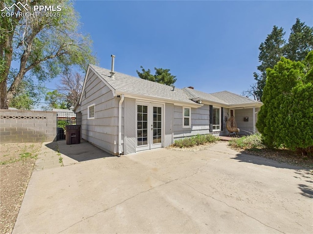 rear view of property featuring fence, french doors, and a patio area