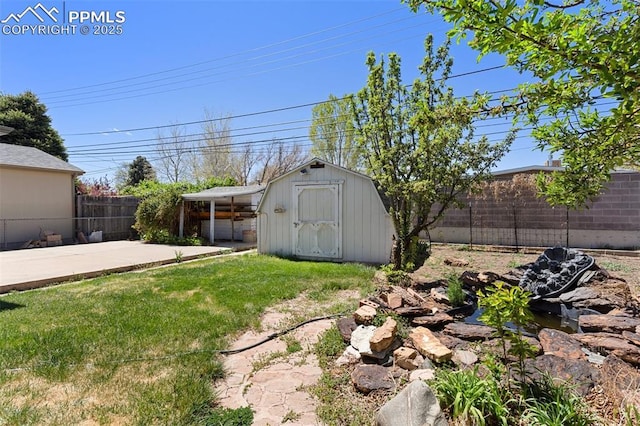 view of yard with a patio, a fenced backyard, a shed, and an outbuilding