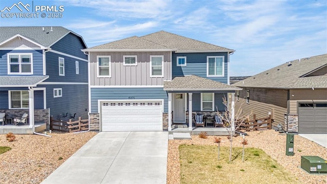 view of front of house featuring fence, covered porch, stone siding, board and batten siding, and driveway
