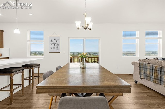 dining space with baseboards, dark wood-type flooring, recessed lighting, and a notable chandelier