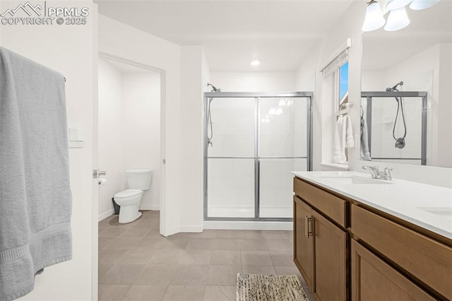 bathroom featuring double vanity, tile patterned flooring, a stall shower, a sink, and toilet