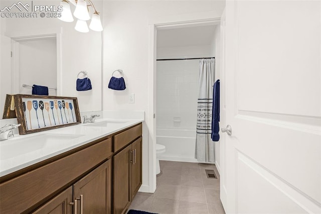 bathroom with a sink, tile patterned flooring, toilet, and double vanity