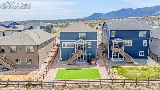 rear view of property with a mountain view, a residential view, stairs, and a fenced backyard