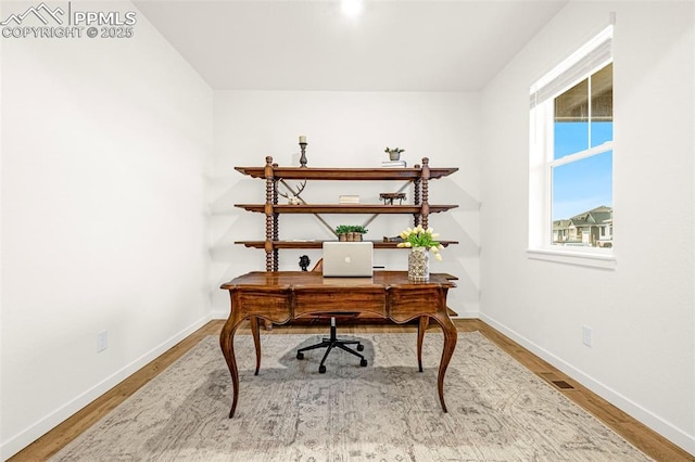 office space featuring visible vents, baseboards, and wood finished floors