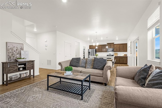 living room featuring visible vents, wood finished floors, stairway, baseboards, and recessed lighting