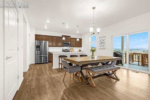 dining area featuring a chandelier, wood finished floors, and visible vents