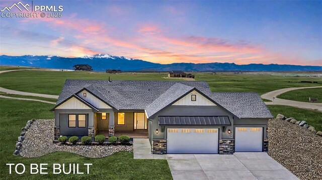 16990 Early Light Dr, Colorado Springs, CO 80908 - view of front of home with a lawn, an attached garage, a mountain view, and stone siding