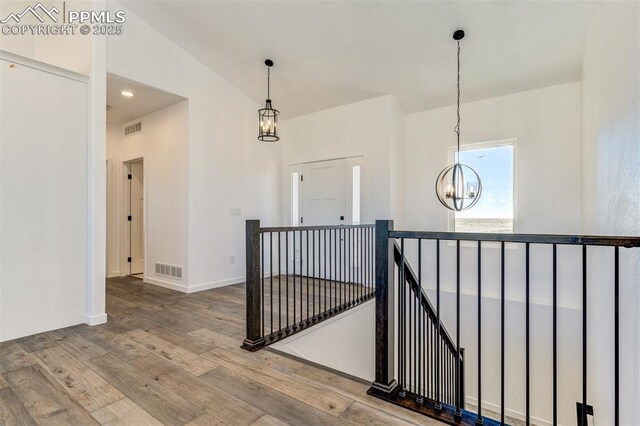 16990 Early Light Dr, Colorado Springs, CO 80908 - corridor featuring visible vents, hardwood / wood-style floors, a chandelier, and an upstairs landing