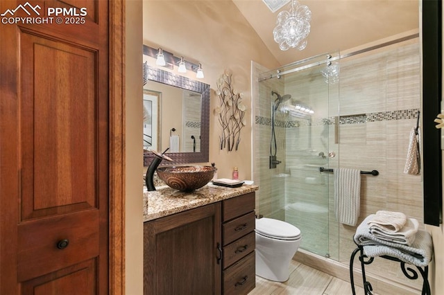full bathroom with vanity, vaulted ceiling, a stall shower, and toilet