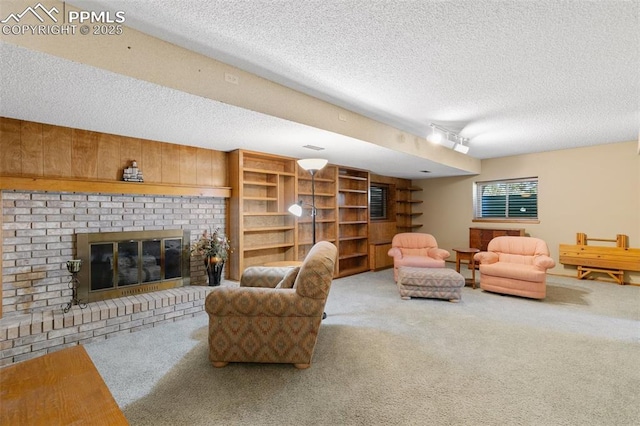 living room with carpet flooring, a textured ceiling, a brick fireplace, and rail lighting