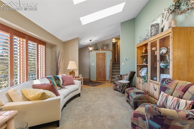 living area featuring vaulted ceiling with skylight, stairway, and light carpet
